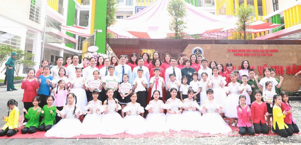 Stadtoberhäupter und Bezirksoberhäupter des Hai Ba Trung machten Erinnerungsfotos mit Lehrern und Schülern der Vo Thi Sau-Grundschule (Bezirk Hai Ba Trung). Foto: Linh Chi