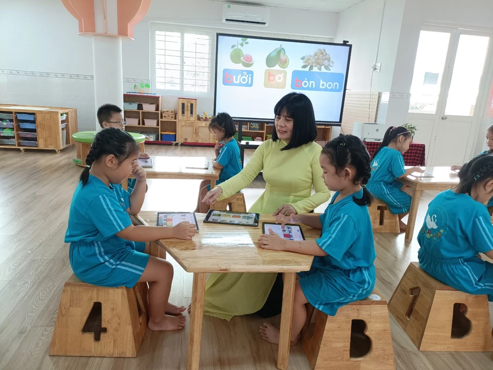 Les enfants apprécient l'utilisation des appareils numériques à la maternelle de la ville (district 3, HCMC)