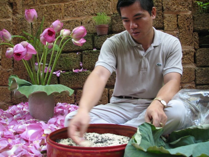 L'artisan Suong fait mariner du riz au lotus avec des feuilles de thé. Photo : NVCC