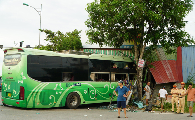 Passenger buses and trucks crashed into a roadside wood workshop. Photo: Lam Son