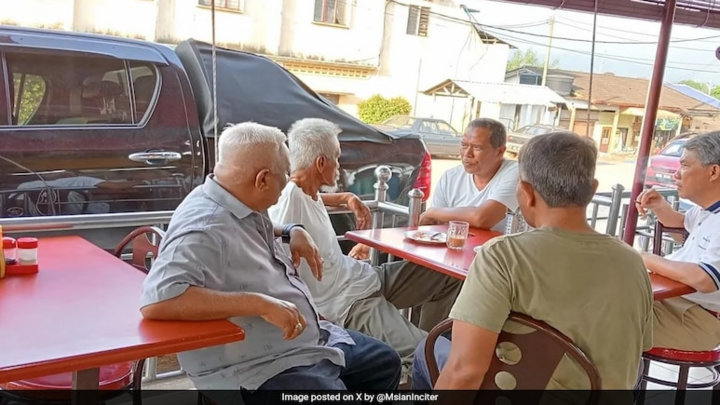 Le ministre malaisien des Affaires étrangères (en chemise à col blanc) fume dans un restaurant.