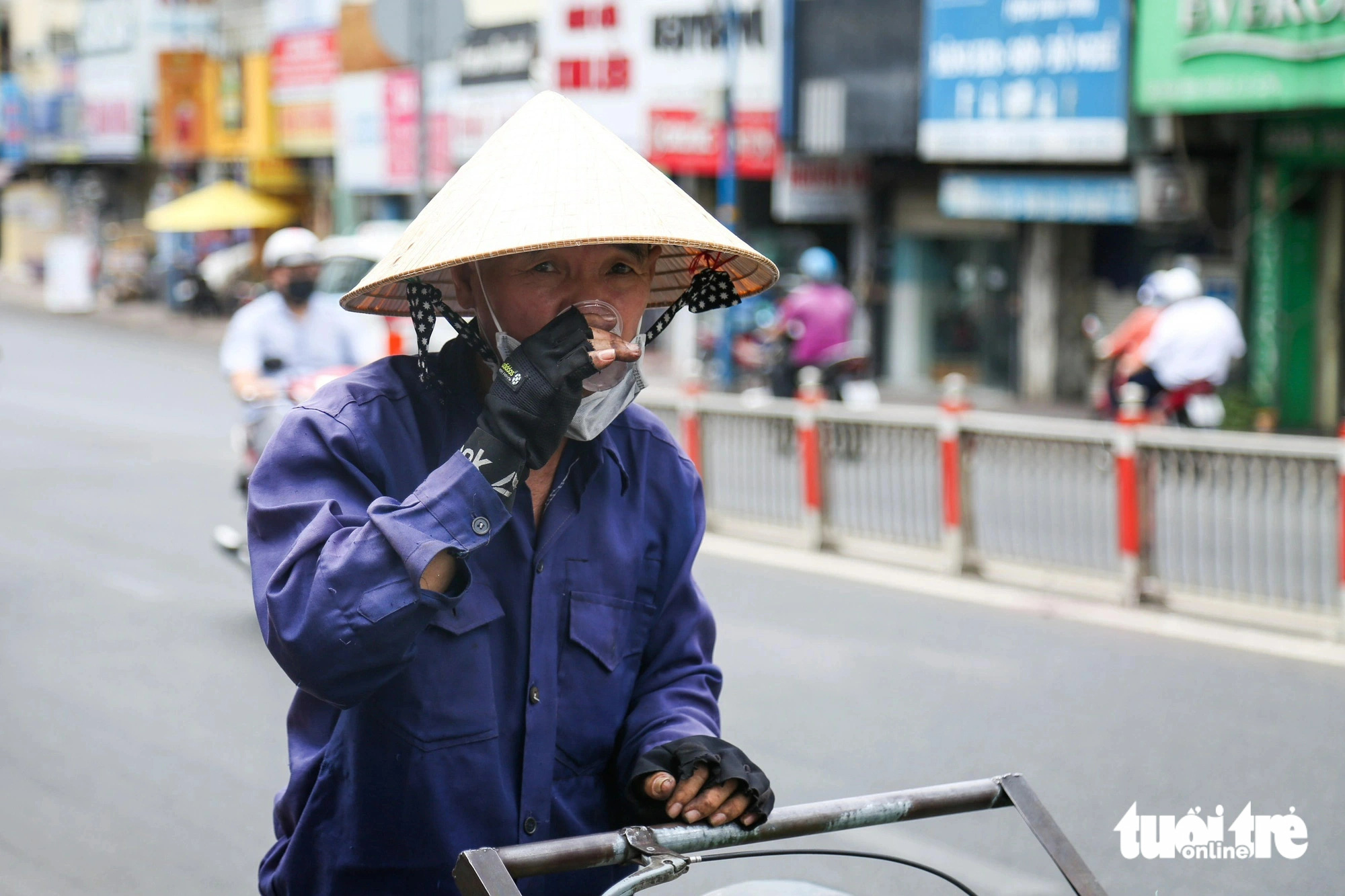 Chú Thành (công nhân vệ sinh) uống nước từ bình nước miễn phí trên đường Phan Đình Phùng (quận Phú Nhuận)