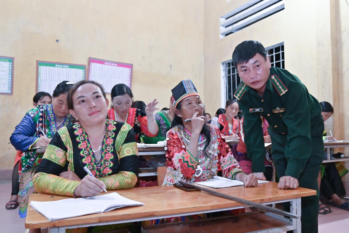 Captain Ho Van Di kindly teaches each letter to women's union members and people of Pa Bua village, Trung Ly commune, Muong Lat district. (Photo: Quoc Toan)