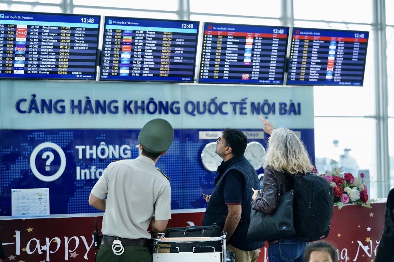 ノイバイ空港で警備員が乗客を案内している。写真：NIA