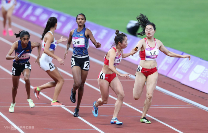 Nguyen Thi Huyen은 19th Asiand에서 열린 여자 4x400 경기에서 Nguyen Thi Hang에게 배턴을 넘겼습니다. 팀은 동메달을 딴 상대 스리랑카보다 0.1초 뒤진 4위를 차지했습니다. 사진: 린 후인