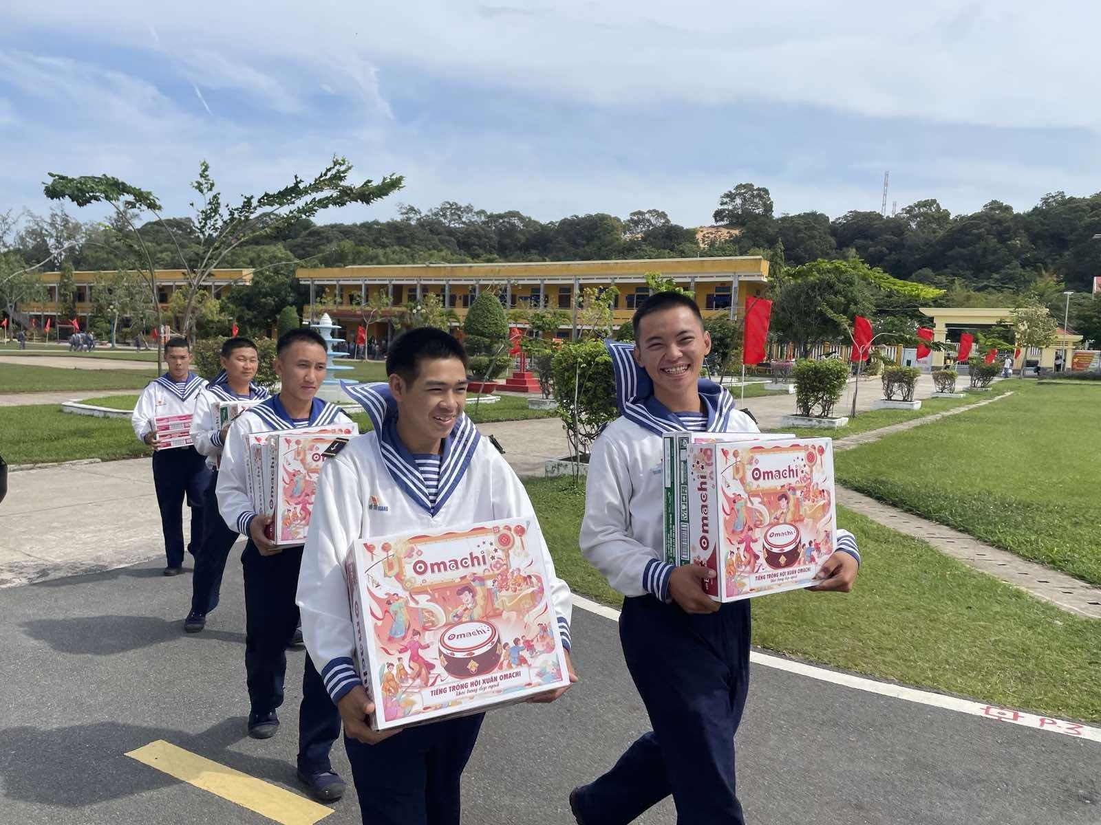 A group of young men carrying boxes Description automatically generated