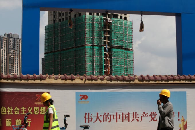 Des ouvriers passent devant le chantier de construction de Country Garden à Kunming, province du Yunnan, en Chine, le 17 septembre 2019. Photo : Reuters