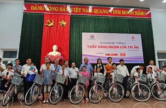 L'ancien vice-Premier ministre Truong Hoa Binh a offert des vélos offerts par le programme de retour aux racines « Allumer la flamme de la gratitude » dans la province de Quang Tri aux étudiants pauvres.