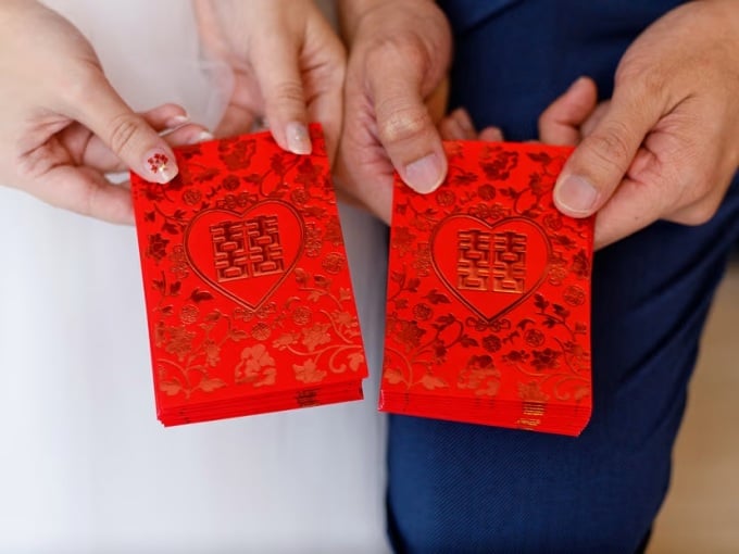 Les mariés reçoivent des enveloppes rouges lors d'un mariage en Chine. Photo : Todayonline