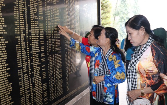 Các thành viên trong đoàn là cựu Thanh niên xung phong xúc động đọc lại từng cái tên liệt sĩ tại Ngã ba Đồng Lộc