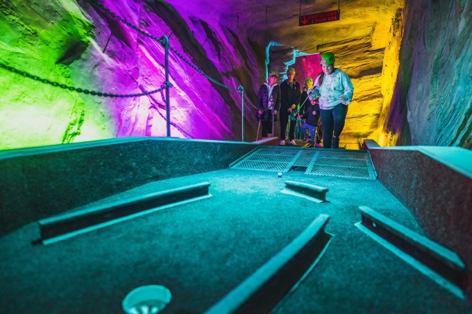 Un touriste met une balle dans un trou sur le terrain de golf situé sur le terrain de la mine de Llechwedd. Photo : Zip World