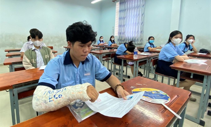 El candidato Nguyen Van Thanh se rompió el brazo derecho y necesitó ayuda para realizar el examen de Literatura. Foto: QN