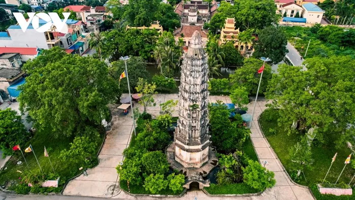 The prominent Nine-Piece Lotus Tower of Co Le Pagoda. At the foot of the tower is a giant turtle statue in the middle of the lake, facing the inside of the pagoda.