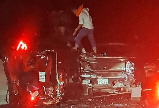 Zwei fünfsitzige Autos überschlugen sich und zerquetschten sich, nachdem sie auf den Mittelstreifen gekracht waren. Foto von : Thai Ha