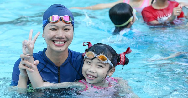 ภาพระยะใกล้ของนักว่ายน้ำ Anh Vien ที่กำลังสอนเด็กๆ ว่ายน้ำอย่างหลงใหล