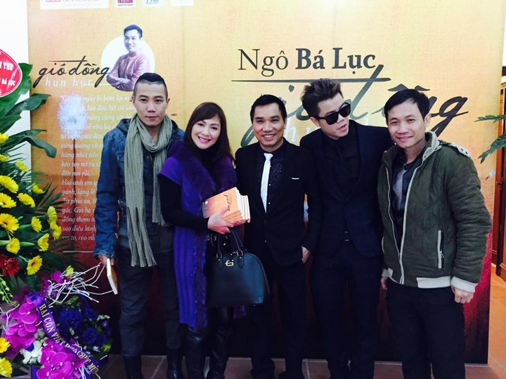 Screenwriter Nguyen Anh Vu (far left) congratulates journalist Ngo Ba Luc on his book launch.