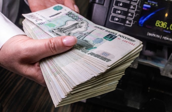 Nhân viên cầm các tờ 1.000 ruble trong một ngân hàng ở Moskva (Nga). Ảnh: Reuters