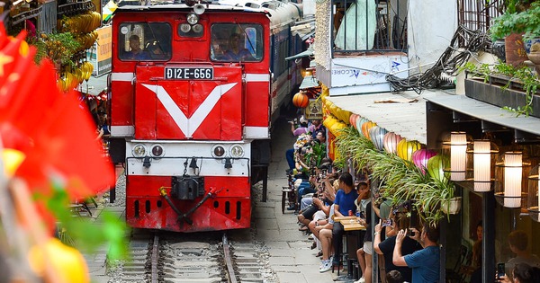 Gold prices dance and tourists pose on the railway tracks in Hanoi