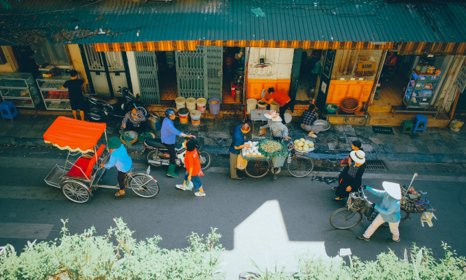 La gente compra comida a vendedores ambulantes en el barrio antiguo de Hanoi. Foto: Hoang Long