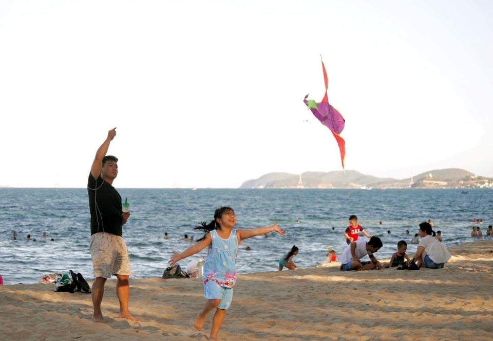 Los turistas disfrutan de la playa durante las vacaciones de verano. Foto: Hoai Nam