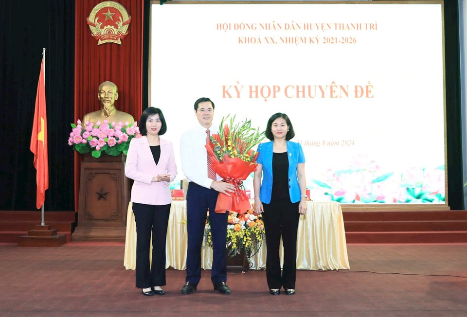 Standing Deputy Secretary of the City Party Committee Nguyen Thi Tuyen and Standing Vice Chairwoman of the Hanoi People's Council Phung Thi Hong Ha presented flowers to congratulate the new Chairman of Thanh Tri District People's Committee Nguyen Xuan Phong.