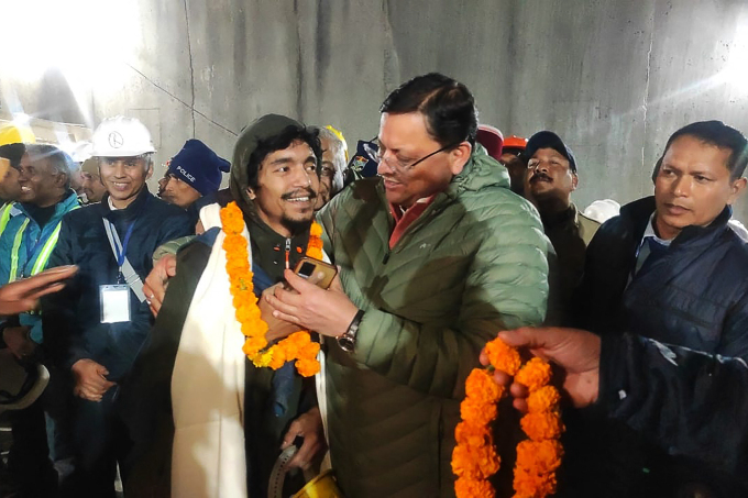 Der Ministerpräsident von Uttarakhand, Pushkar Singh Dhami (rechts), umarmt einen Arbeiter, nachdem er am 28. November aus dem Silkyara-Straßentunnel im Distrikt Uttarkashi gerettet wurde. Foto: AFP