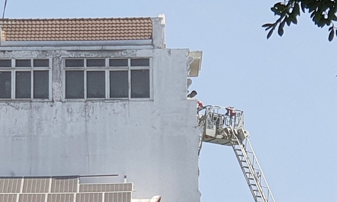 La policía utilizó una escalera de 20 metros de altura para rescatar a personas atrapadas en una casa en llamas. Foto: Dinh Van