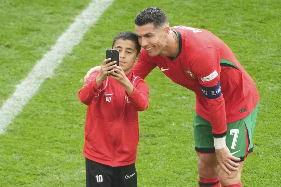 Ronaldo a souri et a pris un selfie avec un jeune fan qui courait sur le terrain.