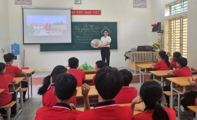 フート県のジア・タン中学校の文学の授業で、タム先生は円錐形の帽子をかぶっています。写真：キャラクター提供