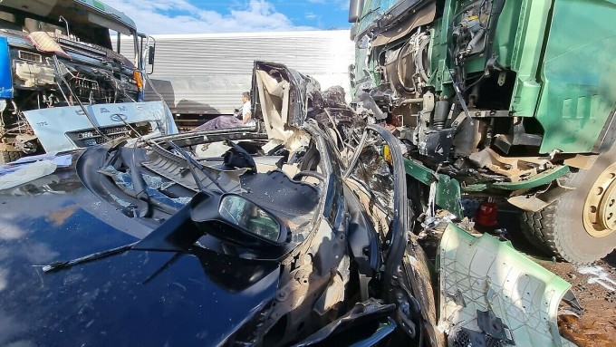 The 5-seat car carrying HAGL Club members was deformed and lying between the two ends of the truck. Photo: Tran Hoa