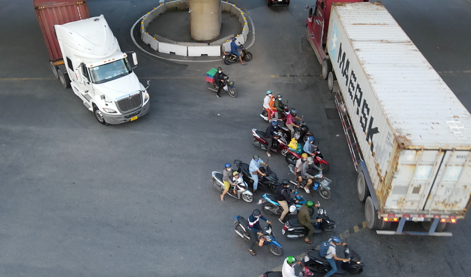 Motocicleta bloqueada entre dos camiones contenedores al pasar por la rotonda de My Thuy. Foto: Dinh Van