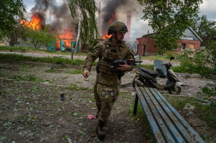 Линь Украинка бежит мимо горящего дома в Волчанске, май 2024 года. (Фото: SCMP)