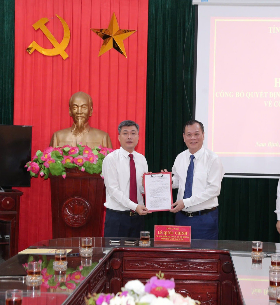 Standing Deputy Secretary of Nam Dinh Provincial Party Committee (right) presents the appointment decision to Mr. Pham Duy Hung. Photo: DH