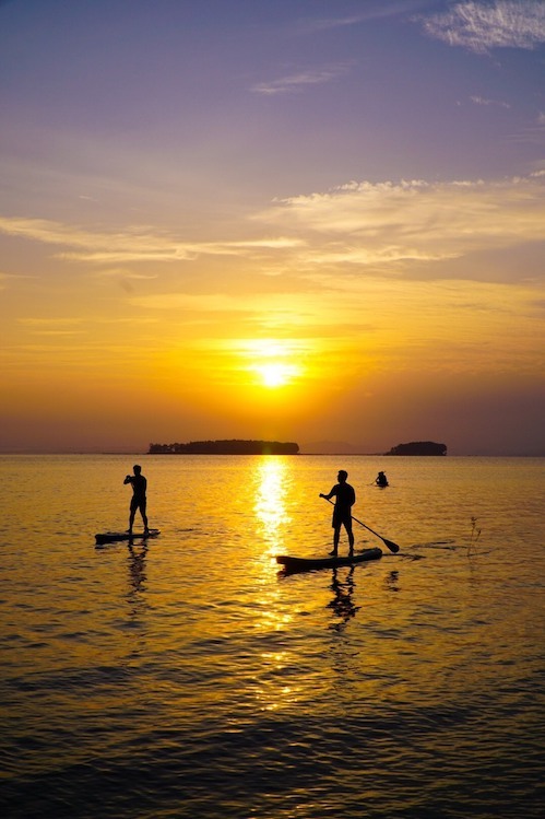 Les touristes pagayent en SUP sur le lac Tri An au coucher du soleil. Photo : Cao Cao Adventures