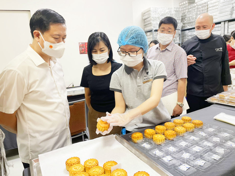 Hotel staff share information about the moon cake production process with the inspection team.