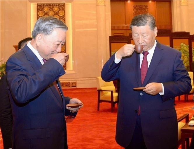 Der Generalsekretär und Präsident Chinas Xi Jinping und der Generalsekretär und Präsident To Lam genießen Tee. Foto: VNA