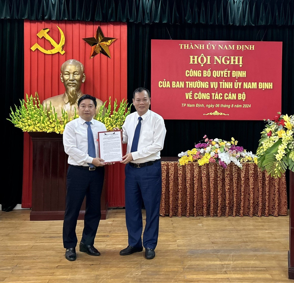 Standing Deputy Secretary of Nam Dinh Provincial Party Committee Le Quoc Chinh (right) presents the Decision to Mr. Nguyen Tien Dung. Photo: DH