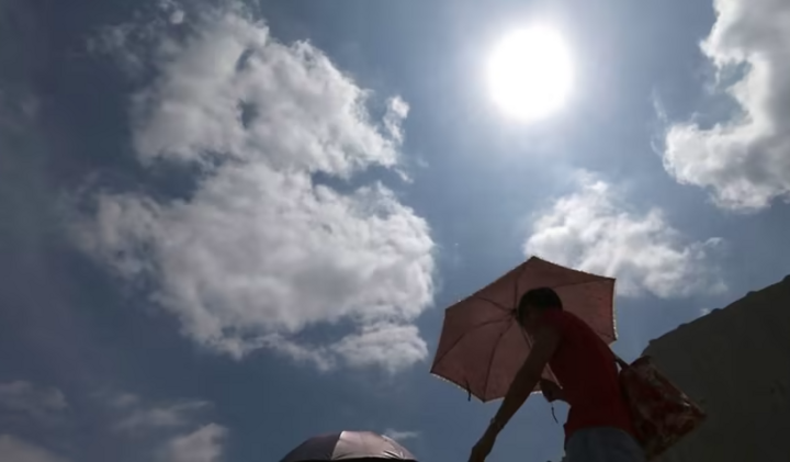 Des gens tenant des parapluies marchant sous le soleil brûlant à Singapour. (Photo : Aujourd'hui)
