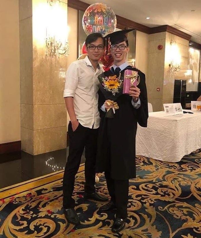 Légende : Nguyet Viet Phuc (chemise blanche) prend une photo avec son jeune frère lors de la cérémonie de remise de son master à Singapour.