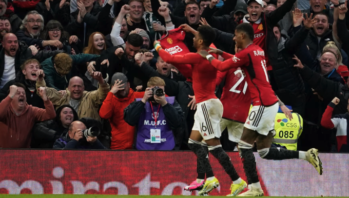 Amad Diallo took off his shirt and shared joy with Man Utd fans after scoring the winning goal. Photo: AP