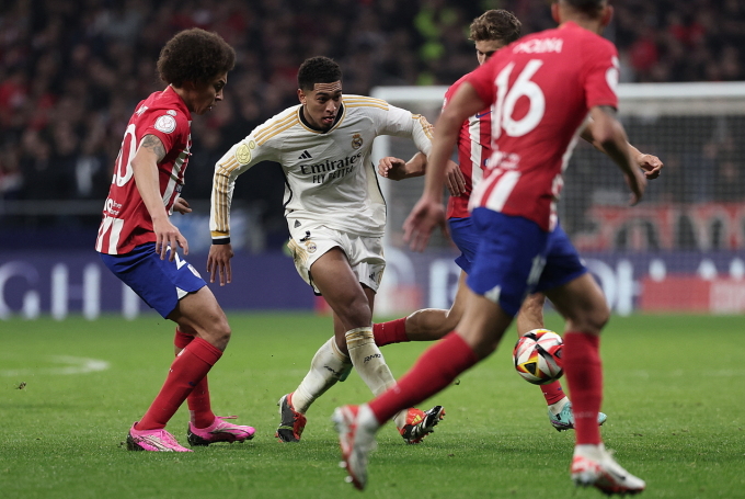 Jude Bellingham dribbelt im Achtelfinale der Copa del Rey zwischen den Spielern von Atletico Madrid. Foto: AFP