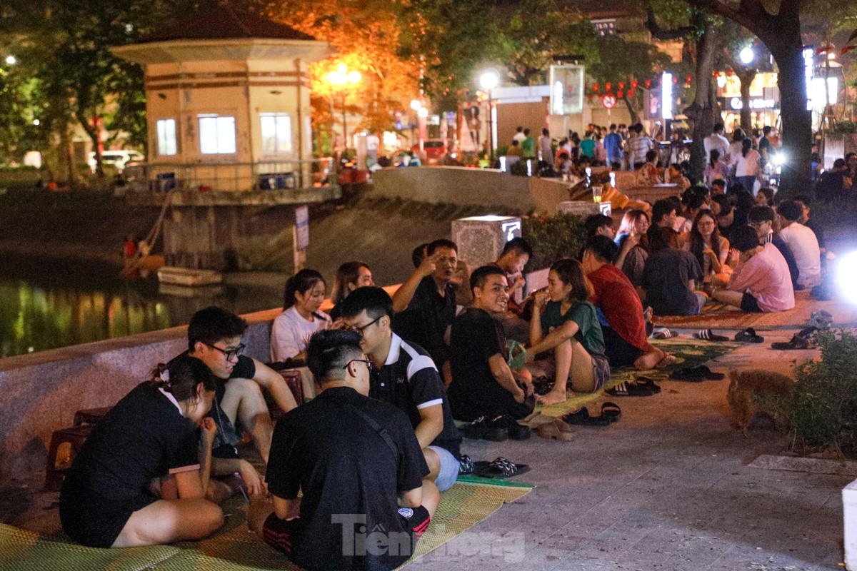 People spread mats and set up tables to drink coffee in the middle of Ngoc Khanh Lake walking street, photo 15