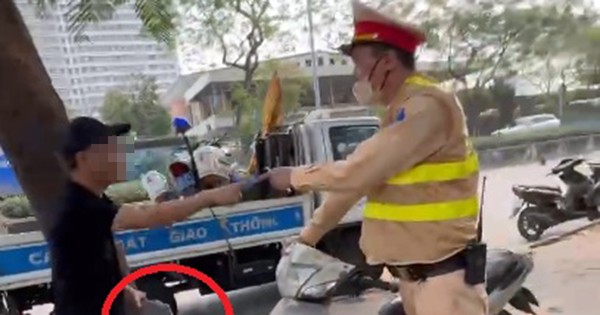 Un hombre usa un ladrillo para destrozar una motocicleta en un control de tráfico.