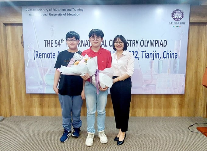 Minh Tuan (au milieu) avec sa mère et son jeune frère ont reçu des fleurs de félicitations lors de la cérémonie d'annonce des résultats de l'Olympiade internationale de chimie dans l'après-midi du 18 juillet 2022. Photo: Binh Minh