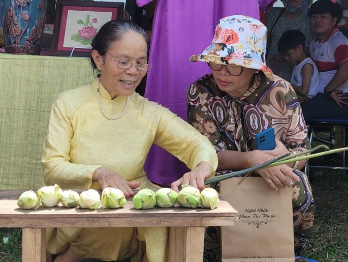 La artesana Phan Thi Thuan demuestra el proceso de elaboración de seda de loto en el Festival de Artesanía Tradicional de Hue 2023. Foto: Thanh Huong  