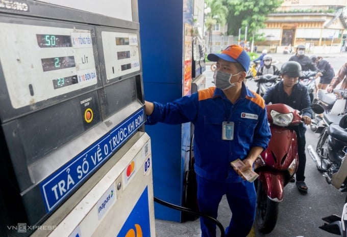 Un employé d'une station-service de la rue Phan Xich Long (district de Phu Nhuan, Ho Chi Minh-Ville) pompe du carburant pour un client, novembre 2022. Photo : Thanh Loc