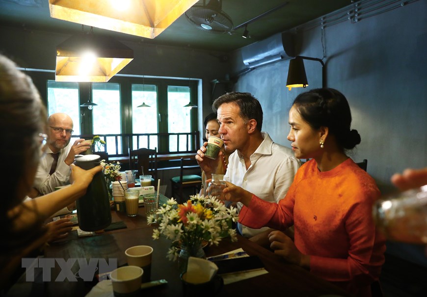 Dutch Prime Minister Mark Rutte drinks tea while chatting with friends in Hanoi. Photo: VNA