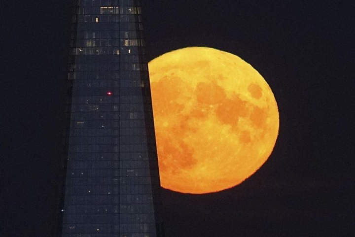 Ein orangefarbener Supermond geht hinter dem Wolkenkratzer The Shard in London, Großbritannien, unter – Foto: AP