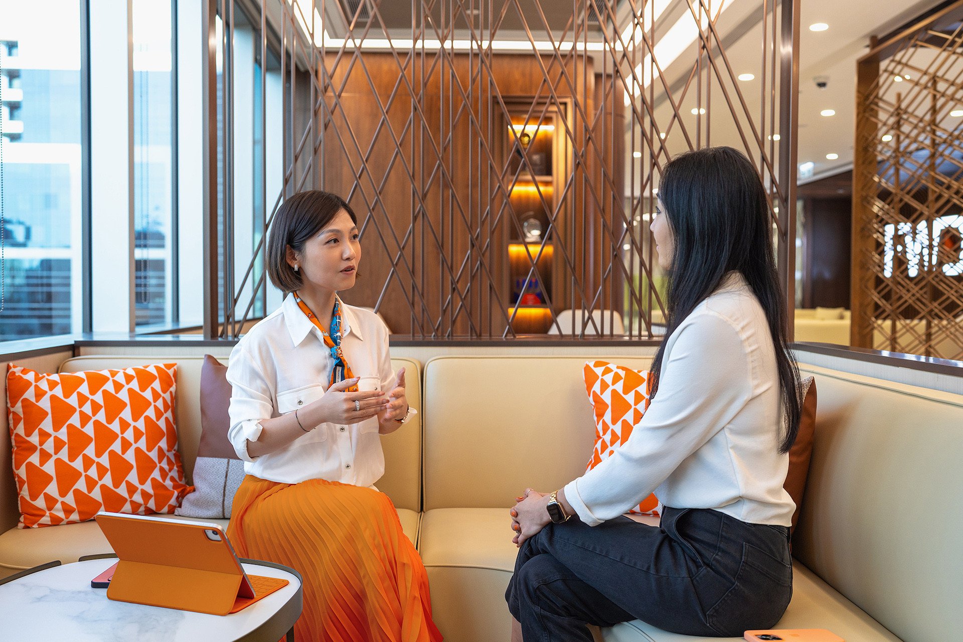 2 female colleagues discuss work in the office lounge.jpg