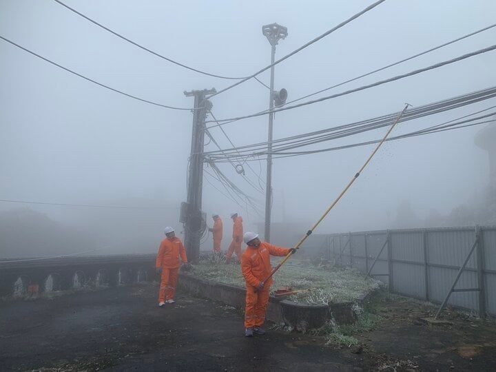 록빈 전력회사 직원들이 전선에서 두꺼운 얼음을 제거하고 있습니다.